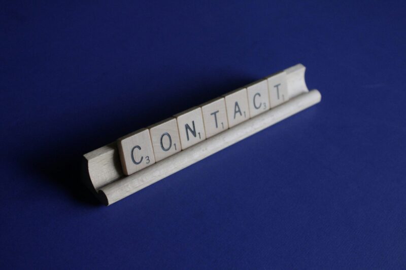 "Contact" spelt out in scrabble tiles